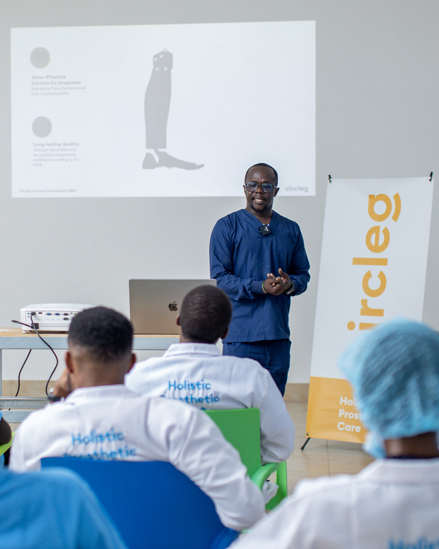 Un prothésiste kenyan forme un groupe de techniciens orthopédistes et prothésistes africains. À l'arrière-plan, on aperçoit la prothèse de jambe, la « circleg ».